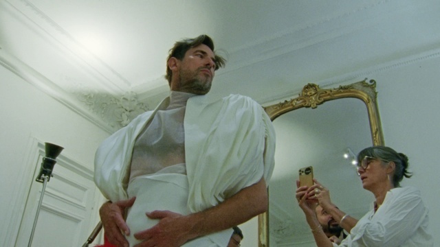 Video Reference: Hand, Arm, Sleeve, Gesture, Beard, Mirror, Event, Picture frame, Wind instrument, Woodwind instrument