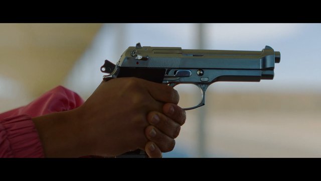 Video Reference: handgun, pistol, firearm, weapon, close-up, hand, aiming, gun, danger, portrait, indoor, blurred background, security, crime, threat
