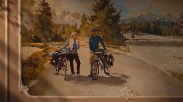 Video Reference: painting, mural, cyclists, bicycles, mountains, snow, trees, road, lake, outdoor, touring bikes, landscape, framed art, wall art