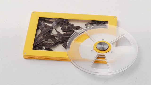 Video Reference: film reel, film canister, motion picture film, reel, transparent lid, yellow case, photographic film, vintage media, analog, storage box, white background, close-up, studio shot