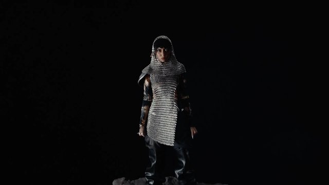 Video Reference: person, fashion, hooded, chainmail, metallic, black background, studio, portrait, avant-garde, runway, dark clothing, model, artistic, isolated, full body