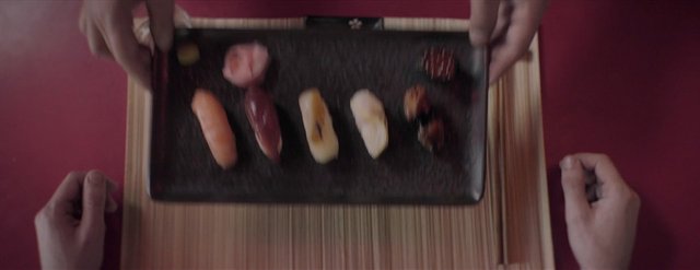 Video Reference: sushi, assorted food, japanese cuisine, tray, top view, table setting, restaurant, hands, food presentation, meal, gourmet, plated food