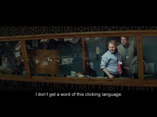 Video Reference: Wood, T-shirt, Font, Advertising, Display device, Room, Photo caption, Beard, Darkness, Signage