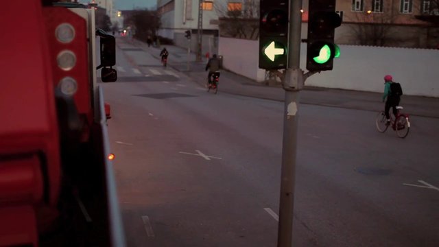 Video Reference: street, intersection, cyclists, bicycle, traffic light, dusk, urban, road, green light, commute, vehicle, motion, outdoor, city