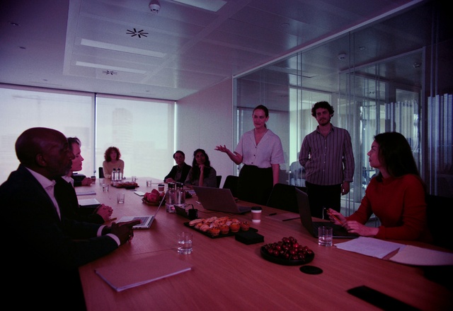 Video Reference: Glasses, Table, Shirt, Coat, Chair, Conference room table, Sharing, Desk, Event, Tableware