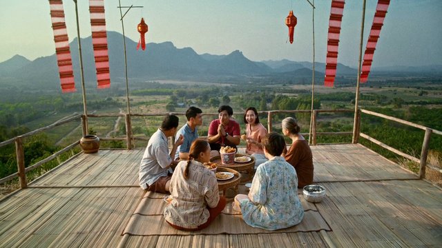 Video Reference: people, group, outdoor, terrace, mountains, valley, landscape, sharing food, meal, travel, scenic view, wooden deck, casual gathering, daylight