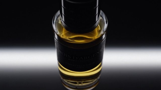 Video Reference: bottle, perfume, fragrance, luxury, product shot, amber liquid, dark glass, black background, reflection, close-up, cosmetic, premium, studio lighting