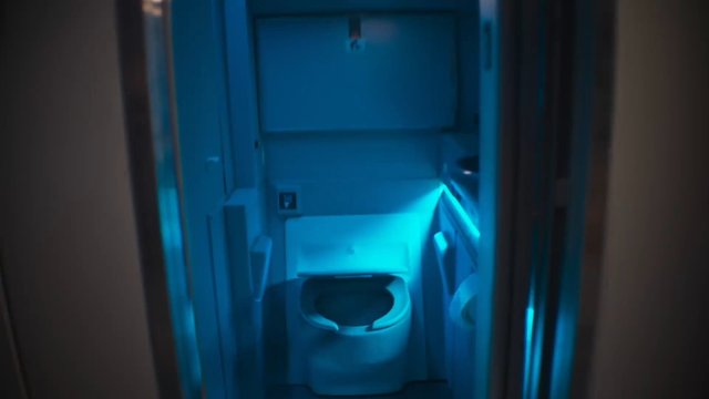 Video Reference: airplane, aircraft lavatory, bathroom, toilet, interior, blue light, cabin, travel, restroom, compact, aerospace, sanitary, doorway