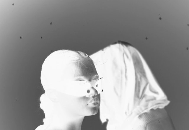 Video Reference: black and white, portrait, close-up, double exposure, abstract, human figure, face, eyewear, high contrast, surreal, minimal background, artistic, negative image, overlay, experimental