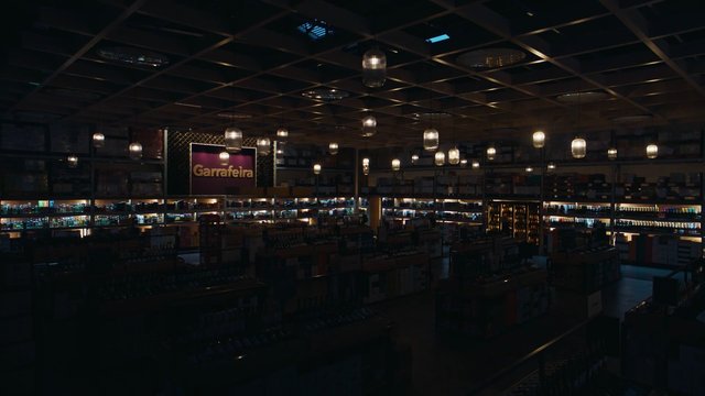 Video Reference: retail, store interior, shelves, pendant lights, dim lighting, sign, aisles, merchandise, shop, wine store, display shelves, indoor, commercial space