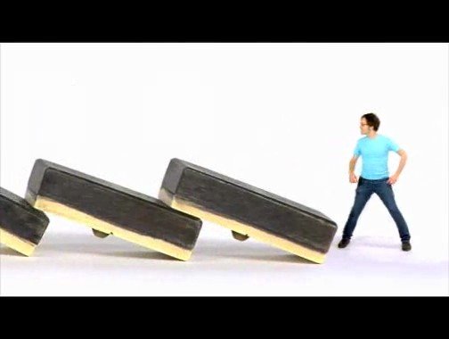 Video Reference: man, dominoes, domino effect, falling blocks, white background, studio shot, standing, blue shirt, action concept, challenge, competition, minimalist, isolated, copy space