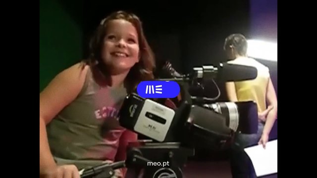 Video Reference: child, smiling, video camera, studio, indoor, people, broadcast, recording, camera equipment, portrait, media, background blur