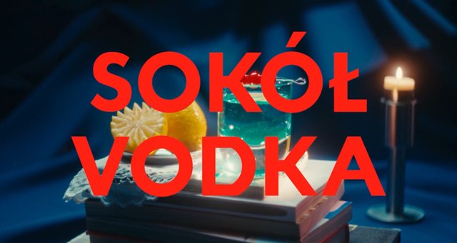 Video Reference: cocktail, vodka, still life, candle, books, citrus, glass, drink, bar, nightlife, blue lighting, text overlay, advertising, beverage, stylized, product shot