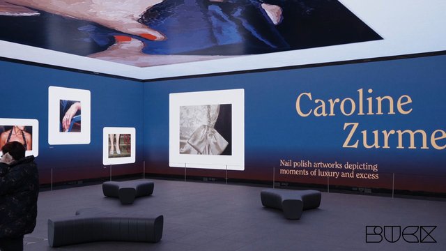Video Reference: exhibition, gallery, fashion, art display, indoor, wall graphic, text, luxury, nail polish, framed images, modern interior, installation, visitor, watermark