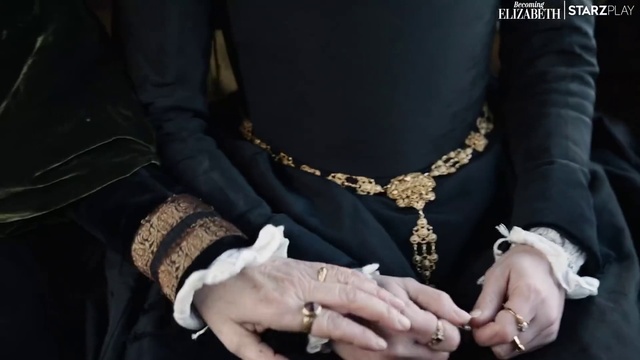 Video Reference: Hand, Outerwear, Arm, Body jewelry, Dress, Black, Human body, Neck, Sleeve, Waist
