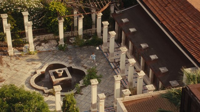 Video Reference: courtyard, fountain, columns, building, roof, tiles, outdoor, overgrown, aerial view, architecture, garden, person, sunlight, abandoned, walkway