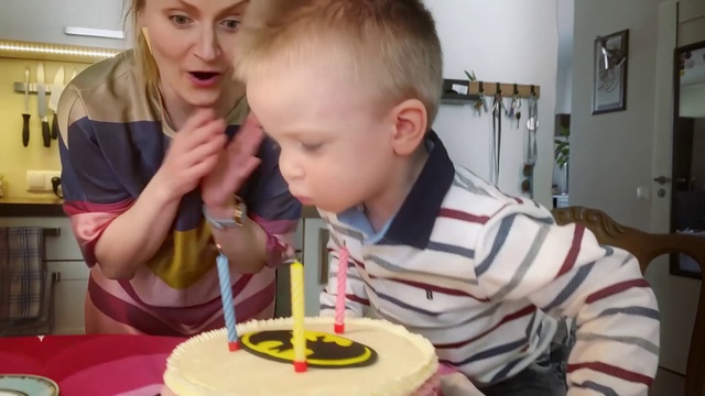 Video Reference: Face, Food, Birthday candle, Candle, Sharing, Cake decorating supply, Picture frame, Birthday party, Tableware, Chair