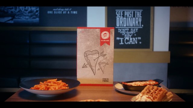 Video Reference: pizza, restaurant, menu, pizza hut, pasta, food, table, dining, advertisement, indoor, meal, plate, cheese, brand, signage