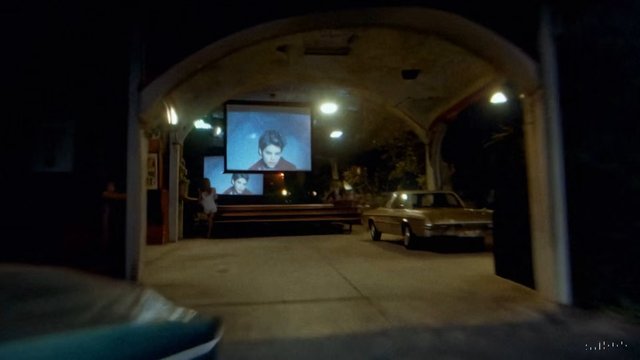 Video Reference: garage, indoor, car, projection screen, video projection, night, dim light, bench, covered driveway, interior, architecture, display, person on screen