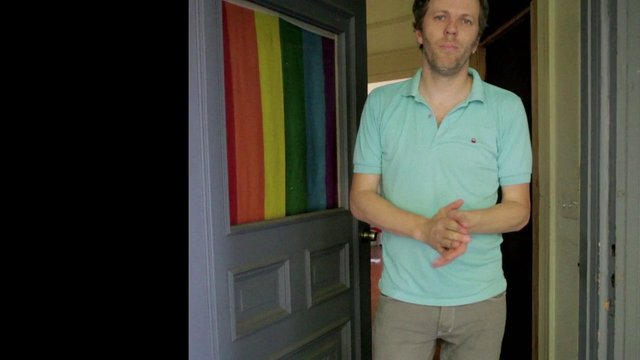Video Reference: man, doorway, standing, indoor, polo shirt, rainbow, curtain, open door, portrait, interior, home, casual, adult