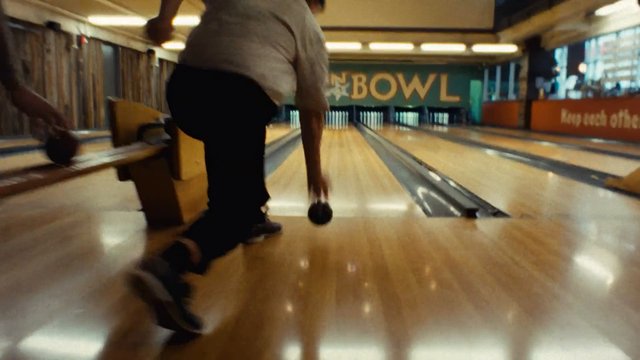 Video Reference: bowling, bowling alley, indoor sports, person, throwing ball, lane, pins, recreation, game, motion blur, sport