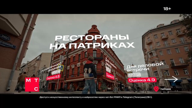 Video Reference: city street, historic buildings, intersection, urban scene, Russian text, advertisement, promotional overlay, pedestrian, architecture, travel, downtown, street view, real estate, restaurant, navigation, outdoor