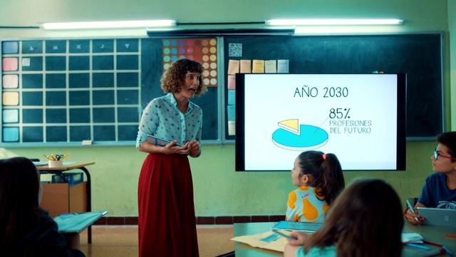 Video Reference: Green, Table, Community, Teacher, Adaptation, T-shirt, Chair, Event, Academic institution, Class