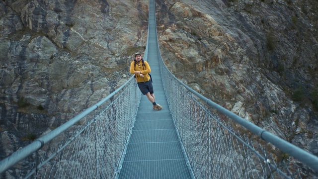 Video Reference: Bedrock, Mountain, Leisure, Rock-climbing equipment, Suspension bridge, Shorts, Rope, Recreation, Sports, Electric blue