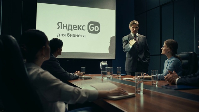 Video Reference: Table, Conference room table, Organism, Chair, Suit, Event, White-collar worker, Job, Microphone, Spokesperson