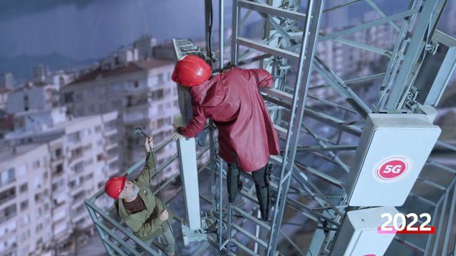 Video Reference: telecommunications, tower, workers, hard hats, maintenance, construction, heights, metal structure, urban, industrial, climbing, antenna, safety gear, 5G, cityscape