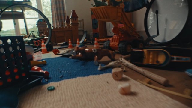 Video Reference: toy room, clutter, indoor, playroom, toy vehicles, traffic cones, toy castle, rug, window light, scattered objects, child play, low angle, messy floor, miniature scene