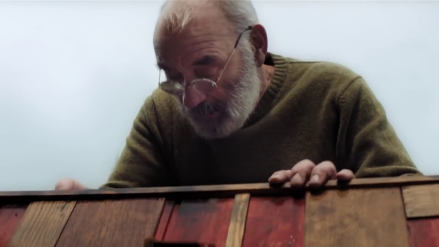 Video Reference: Head, Chin, Shirt, Mouth, Beard, Wood, Musical instrument, T-shirt, Facial hair, Wrinkle