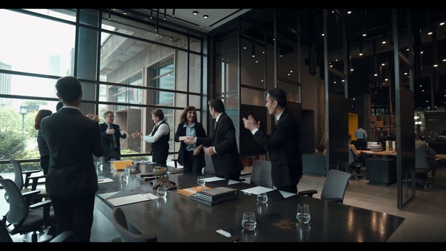 Video Reference: Table, Coat, Chair, Suit, Conference room table, Building, White-collar worker, Event, Drinkware, Tableware