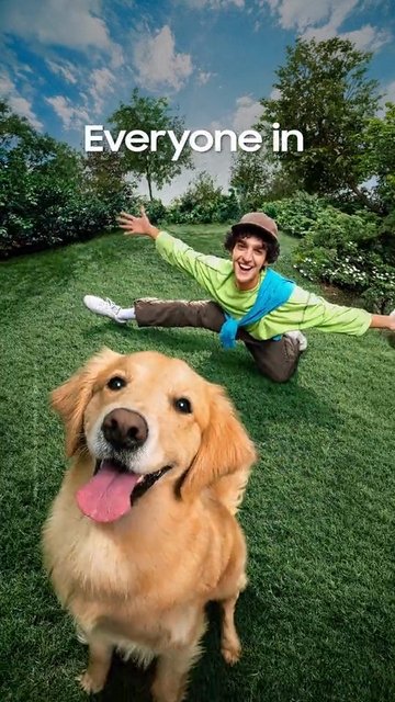Video Reference: golden retriever, dog, park, grass, person, smiling, outdoor, trees, sky, clouds, playful, pose, selfie, wide angle, text overlay