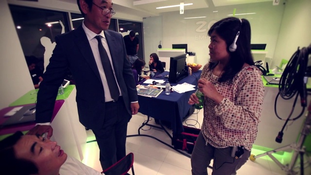 Video Reference: Tie, Human, Fashion, Purple, Lighting, Interior design, Interaction, Social group, Chair, Suit