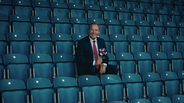 Video Reference: Clothing, Furniture, Coat, Blue, Chair, Product, World, Tie, Entertainment, Suit