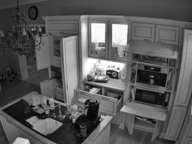 Video Reference: kitchen, interior, home, cabinets, sink, island, countertop, appliances, open cabinets, black and white, indoor, household, storage, lighting, messy, room