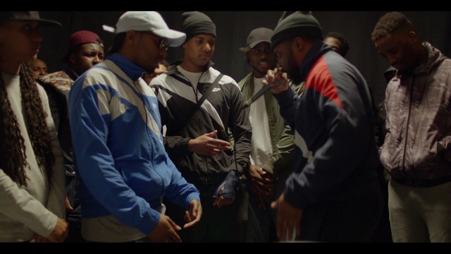 Video Reference: Cap, Gesture, Baseball cap, Headgear, Hat, Event, Crowd, Conversation, Team, Darkness
