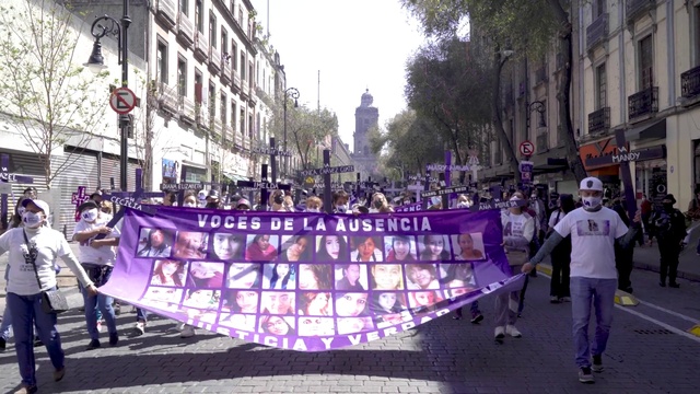 Video Reference: Footwear, Trousers, Purple, Building, Tree, Crowd, Sky, City, Metropolitan area, Event