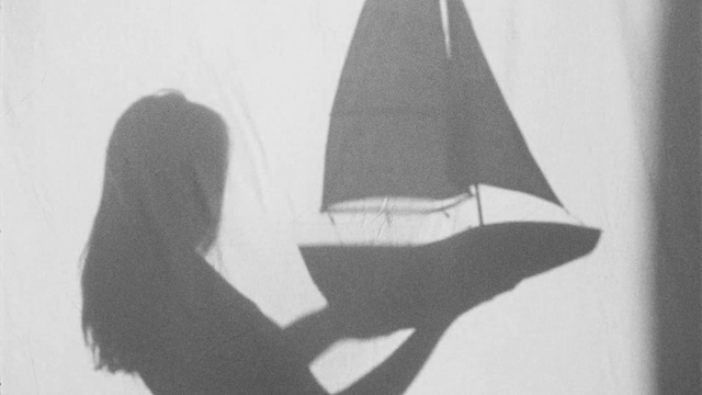 Video Reference: Hair, Outerwear, Hand, Human body, Gesture, Triangle, Headgear, Art, Tints and shades, Font