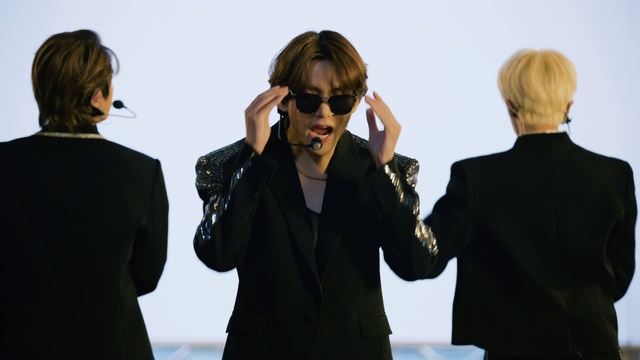 Video Reference: Vision care, Goggles, Sunglasses, Sleeve, Coat, Gesture, Eyewear, Street fashion, Fashion design, Formal wear