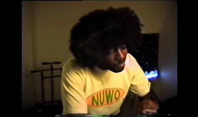 Video Reference: Jheri curl, Sleeve, T-shirt, Afro, Fun, Darkness, Event, Room, Musical instrument accessory, Entertainment
