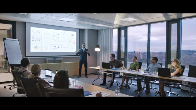 Video Reference: Table, Furniture, Building, Computer, Chair, Interior design, Desk, Communication Device, Laptop, Suit