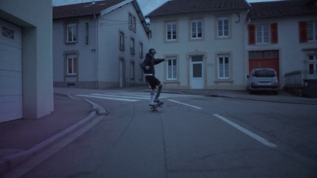 Video Reference: Building, Wheel, Window, House, Asphalt, Tire, Road surface, Grey, Skateboarder, Rolling