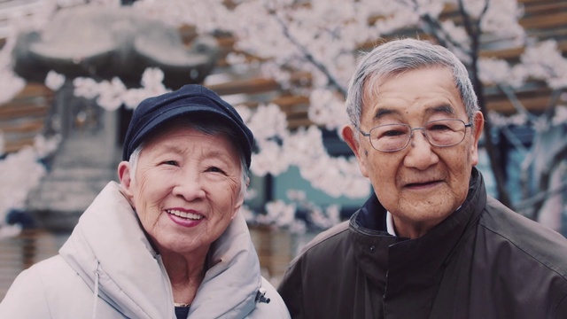 Video Reference: Clothing, Forehead, Skin, Outerwear, Hairstyle, Smile, Daytime, Photograph, Eye, Organ