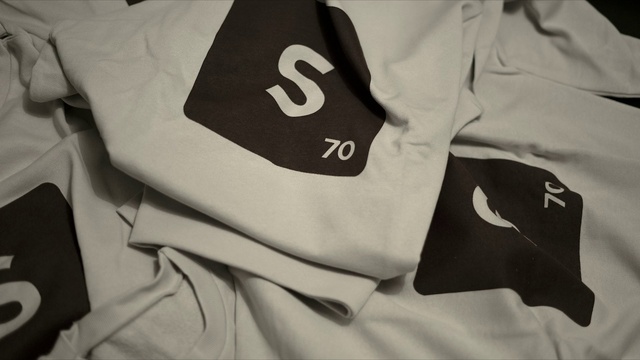 Video Reference: Outerwear, Product, Textile, Neck, T-shirt, Sleeve, Font, Grey, Collar, Material property