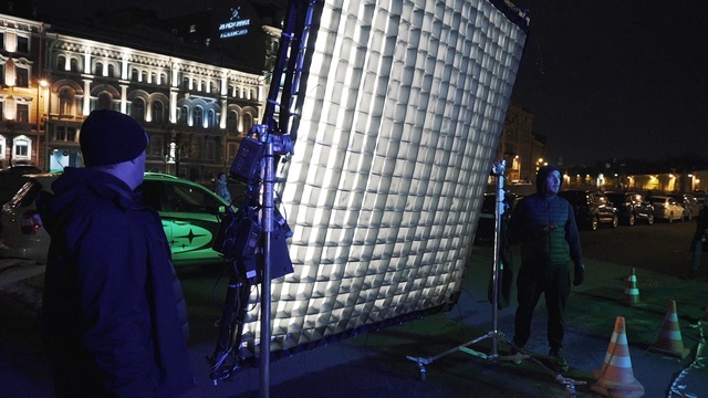 Video Reference: Architecture, Building, Automotive tire, Automotive lighting, City, Jacket, Electric blue, Human settlement, Event, Darkness