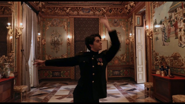 Video Reference: Picture frame, Curtain, Temple, Textile, Gesture, Flash photography, Formal wear, Suit, Overcoat, Event