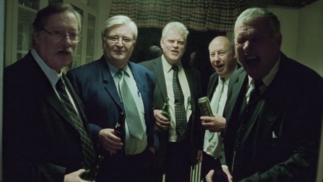 Video Reference: Glasses, Coat, Tie, Gesture, Suit, Social group, Tableware, Blazer, Formal wear, Collar