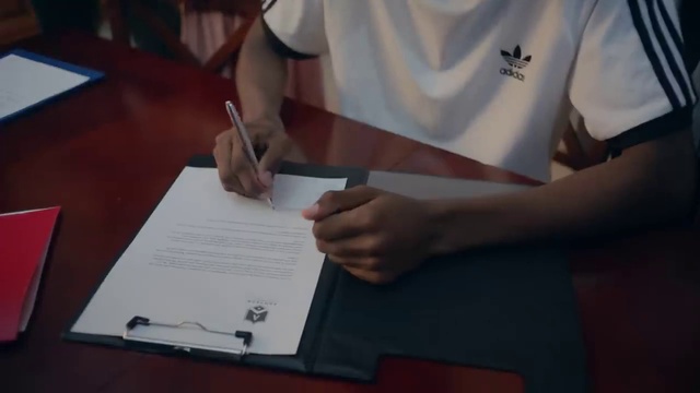 Video Reference: Hand, Sleeve, Gesture, Finger, Writing instrument accessory, Font, Table, Nail, Office instrument, Desk